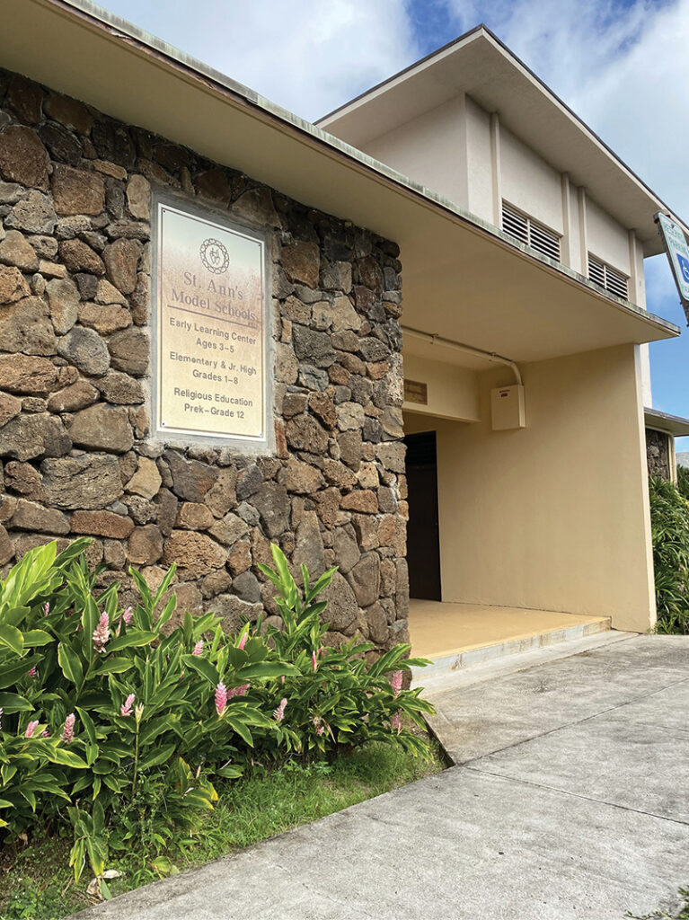 Rock wall and sign on front of school building